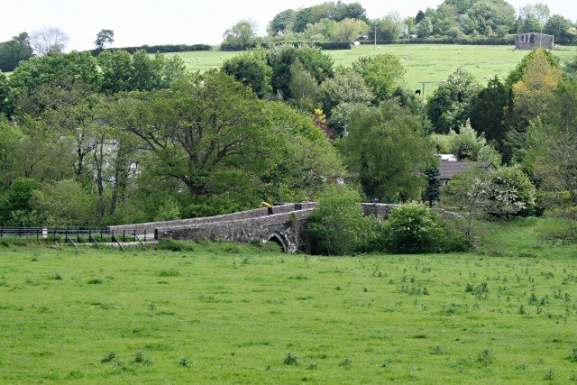 The medieval stone bridge at Horsebridge crossing the River Tamar, seen from the Cornish bank across a pasture field